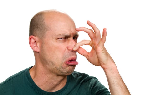 A balding man holding his nose