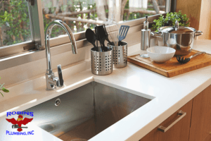A kitchen faucet and sink with Robins Plumbing logo