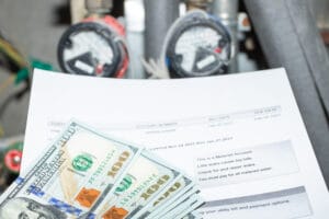 US dollars sitting on top of a utility bill.