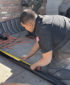 A picture of a plumber with Robins Plumbing measuring sewer line pipes.