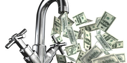 A faucet spraying dollar bills