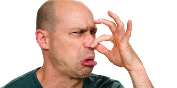 A balding man holding his nose