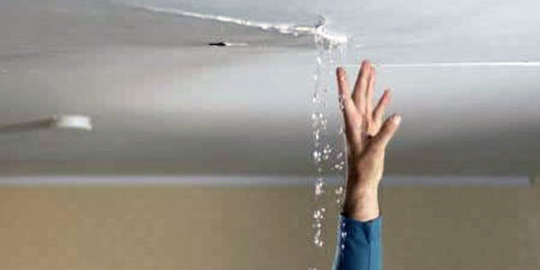 Crack in ceiling with water pouring out and hand reaching upwards towards crack for blog "Avoid Water Damage from Your Air Conditioner"