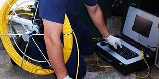 Plumbing tech using a sewer camera and monitor system for blog "Plumbing and Technology for Property Managers"